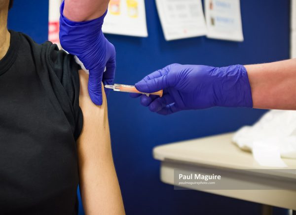 Asian woman getting injection in arm UK