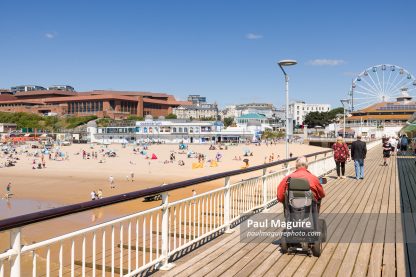 Elderly man on a mobility scooter at Bournemouth Pier, UK