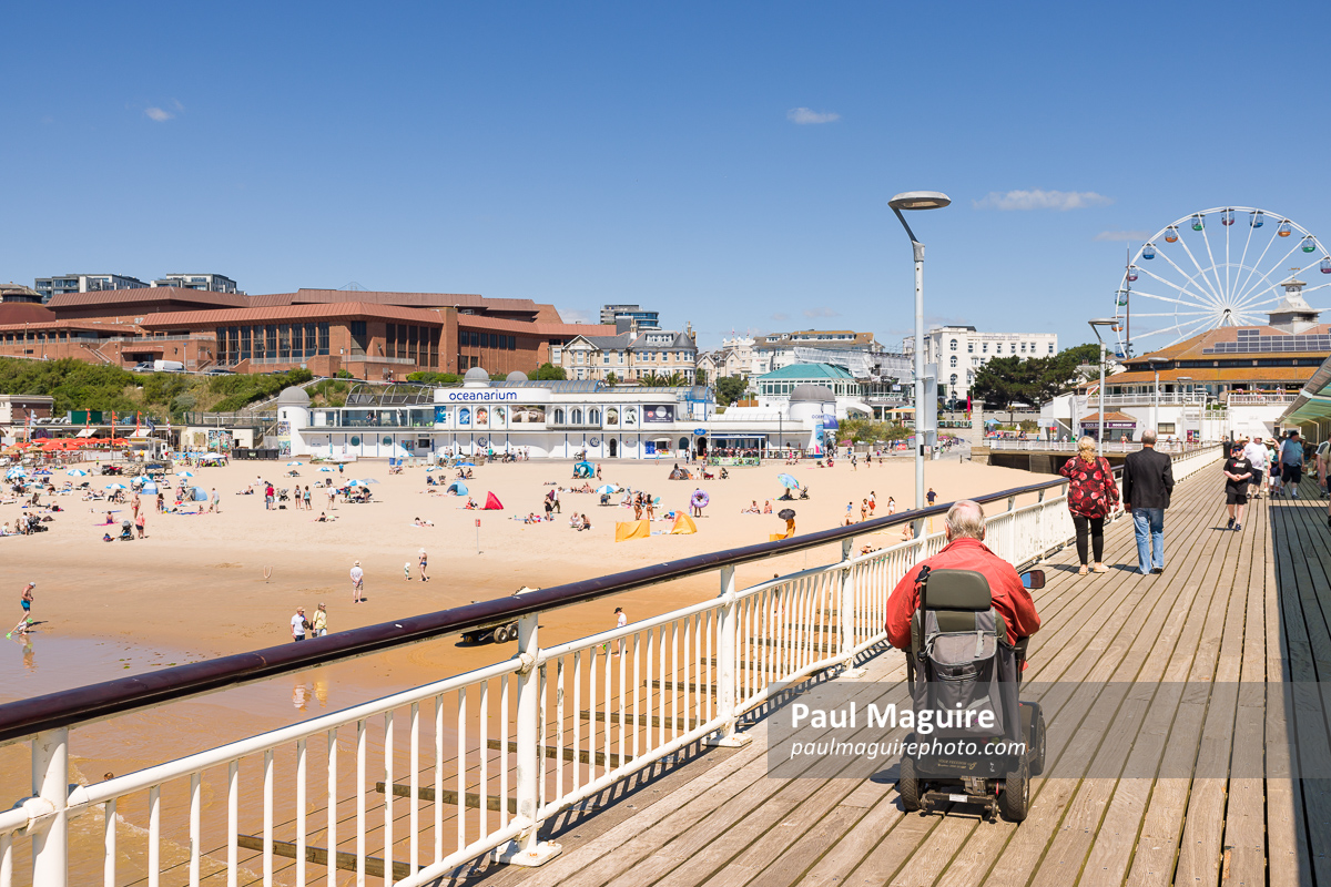 Elderly man on a mobility scooter at Bournemouth Pier, UK