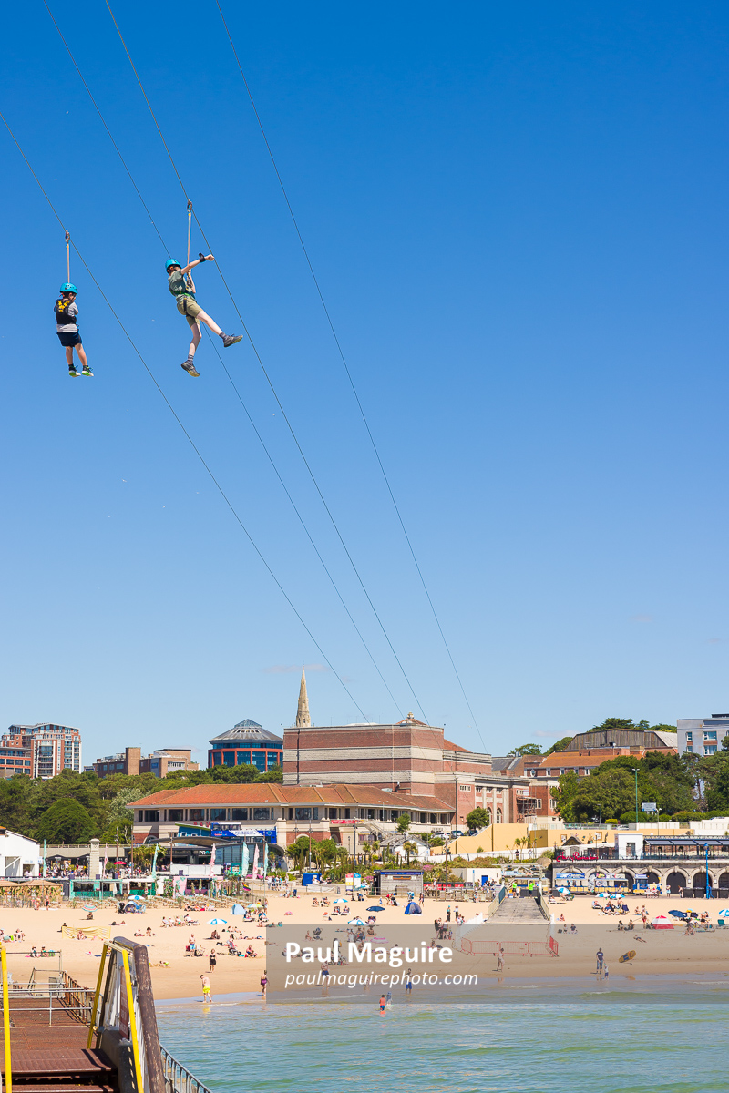 Children on Pierzip zip wire (zip line) Bournemouth beach, UK