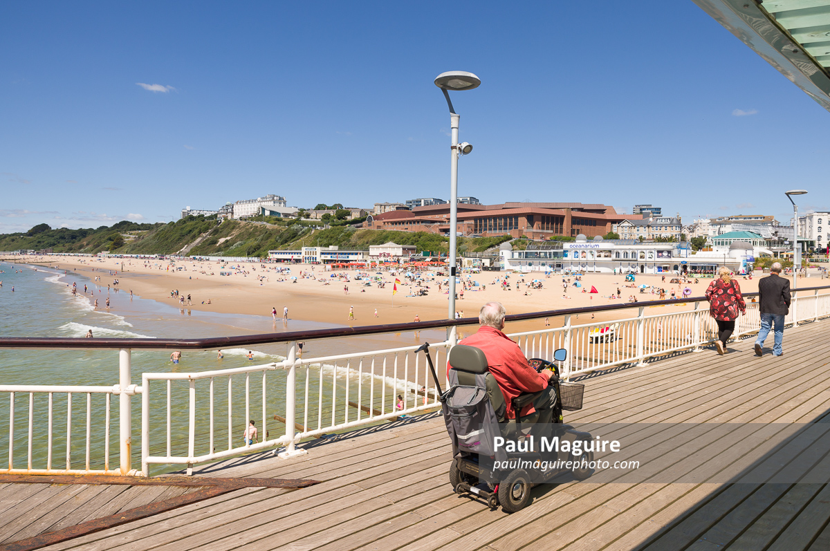Old man on a mobility scooter at Bournemouth Pier, UK