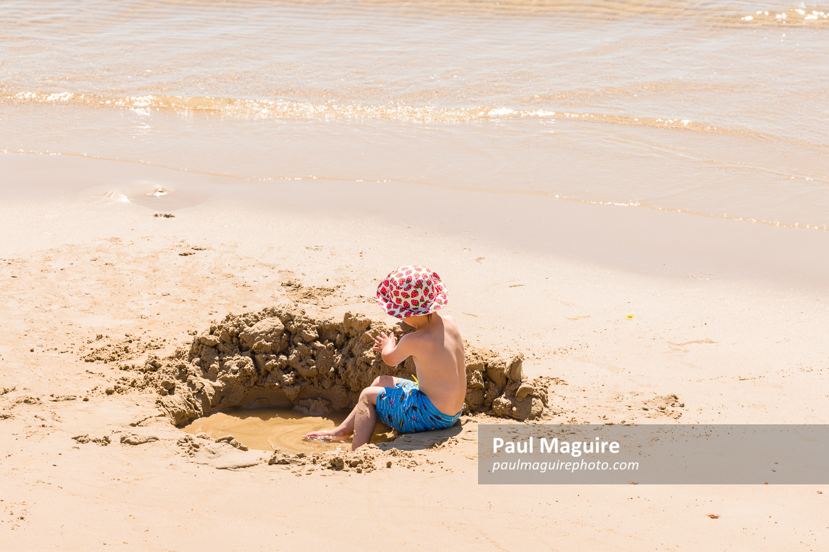 Boy playing in sand on Bournemouth beach, Dorset, UK