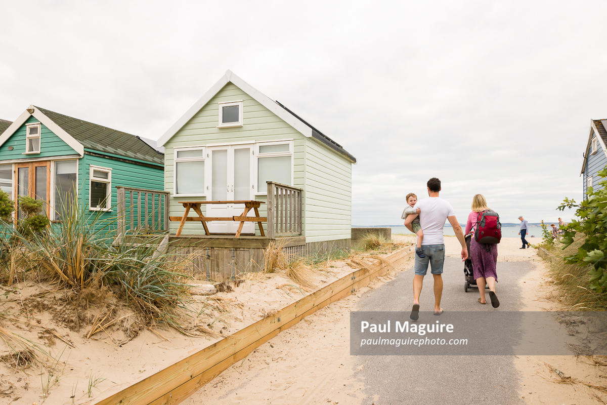 Beach huts at seaside in Dorset UK with young family on holiday