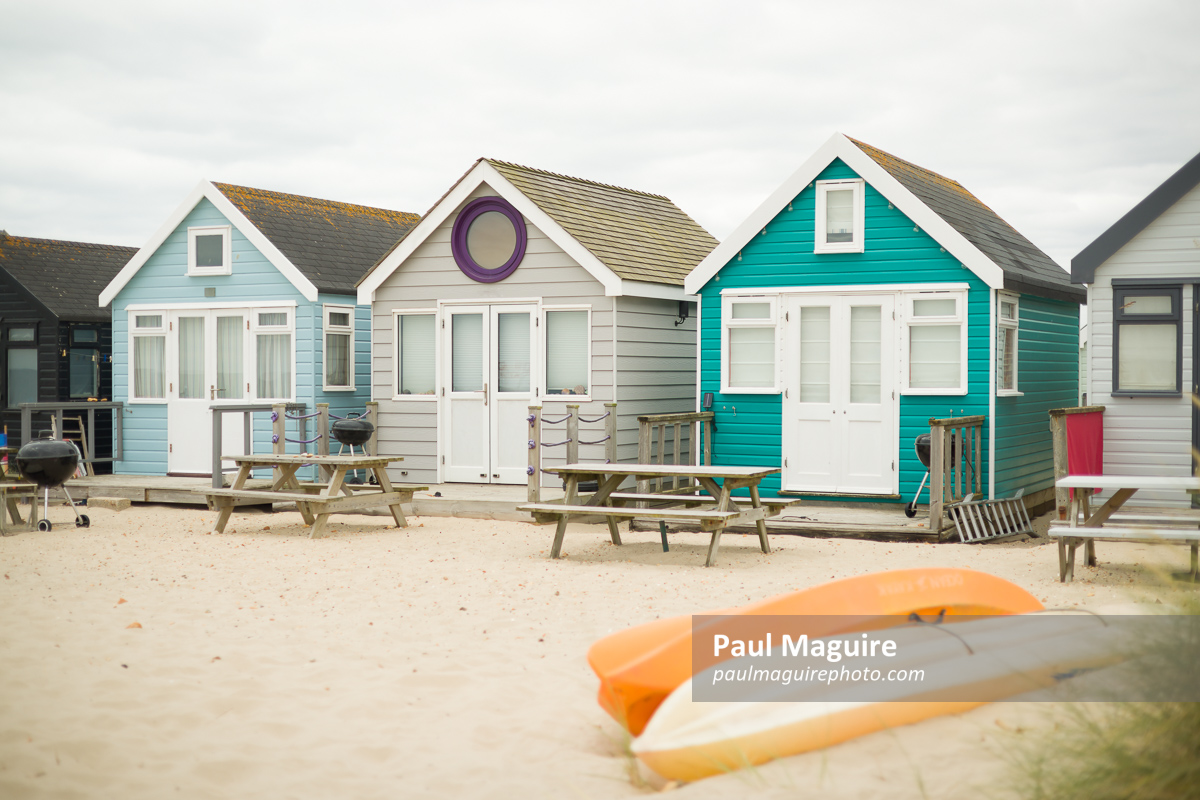 Wooden beach huts on seaside in summer. Dorset, UK