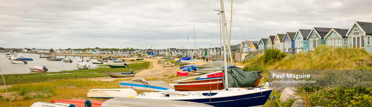 Boats and beach huts at the seaside. Dorset coast, UK