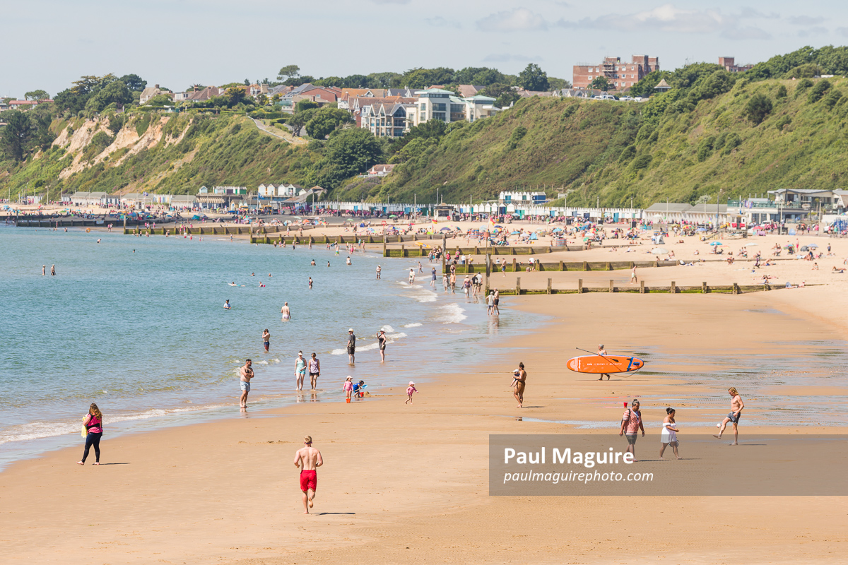 Man jogging on Bournemouth beach in summer, Dorset, UK