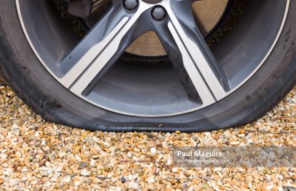 Flat tyre (tire) on a car wheel, close up of car tyre puncture