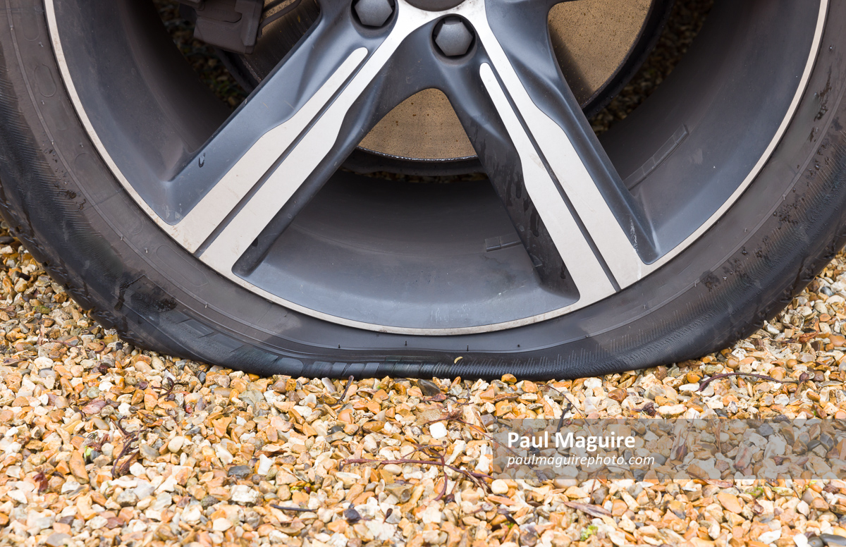 Flat tyre (tire) on a car wheel, close up of car tyre puncture